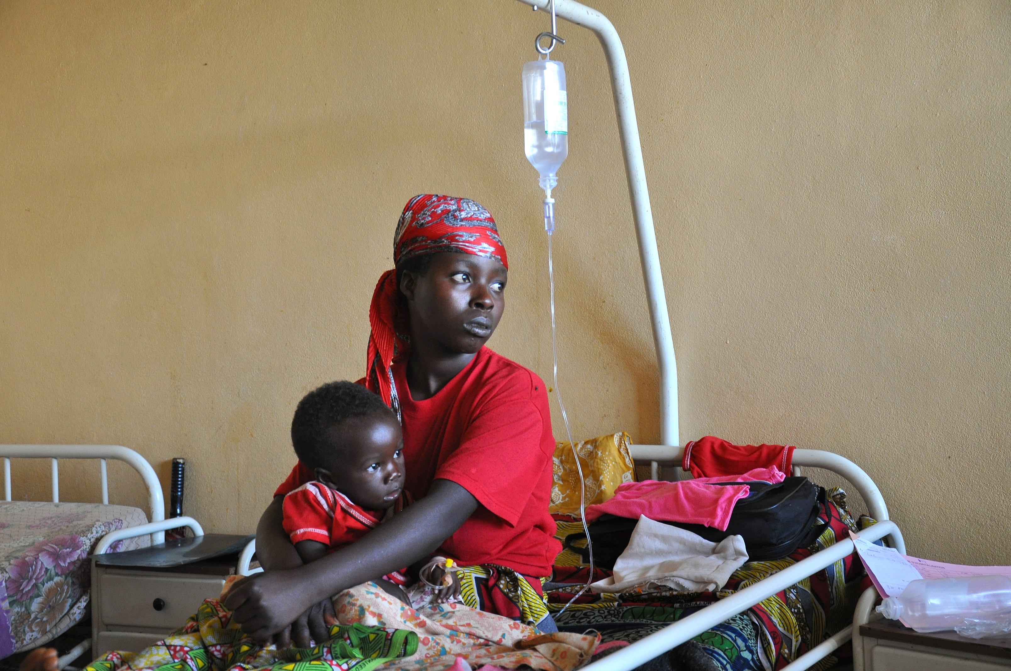 Une mère et son enfant soignés pour le paludisme dans un hôpital du Burundi. Le gouvernement du pays fournit des soins de santé gratuits aux femmes enceintes et aux enfants de moins de cinq ans. Burundi, 12 mars 2009. Photographie utilisée avec l'autorisation du PNUD via Flickr CC BY-NC-ND 2.0.