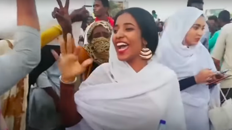 Alaa Salah est devenue un symbole du rôle des femmes dans le soulèvement contre le chef autocratique du Soudan Omar al-Bashir, qui a été évincé par l'armée. Les images d'elle chantant des chansons traditionnelles lors des manifestations à Khartoum sont devenues virales sur les réseaux sociaux, où les femmes et les minorités au Soudan sont souvent confrontées à un harcèlement en ligne intense. Capture d'écran via VOA / YouTube, 16 avril 2019.