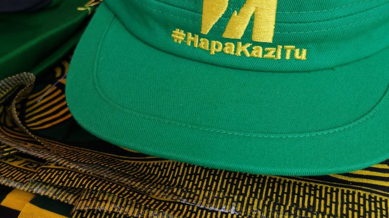 Les progrès de la Tanzanie ne pouvaient pas se faire assez vite, lorsque le président John Magufuli a pris le pouvoir en 2015. « Hapa Kazi Tu » (en français : « Ici, on travaille sans relâche ») le slogan du regretté Magufuli, vu sur une casquette verte et jaune aux couleurs du CCM, le parti de M. Magufuli, qui est actuellement au pouvoir. Photo de Pernille Baerendtsen, utilisée avec permission.
